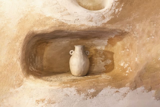 A white vase sitting in a wall alcove 