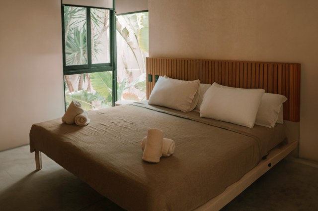 A bedroom with a large bed and window in the background