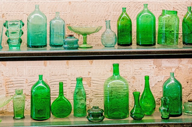 Shelves filled with different colored glass vases