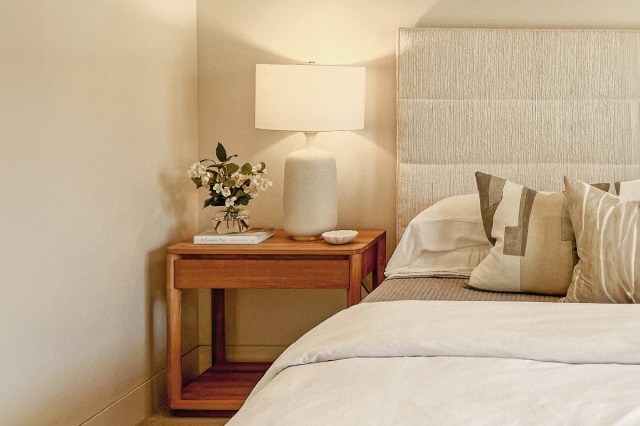 A neatly made bed with a nightstand 