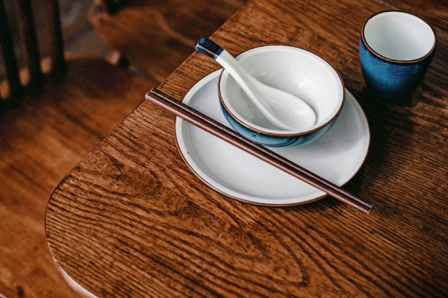 An empty bowl with a spoon on a wooden table