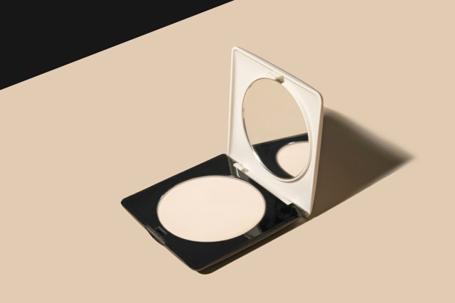 A mirror compact resting open on a bathroom counter