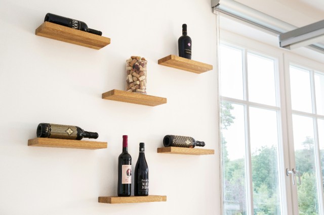 Wine bottles on brown floating shelves