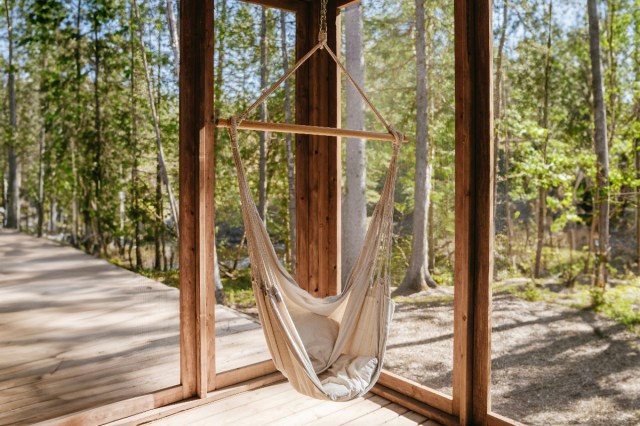 A hammock hanging in a room with windows 