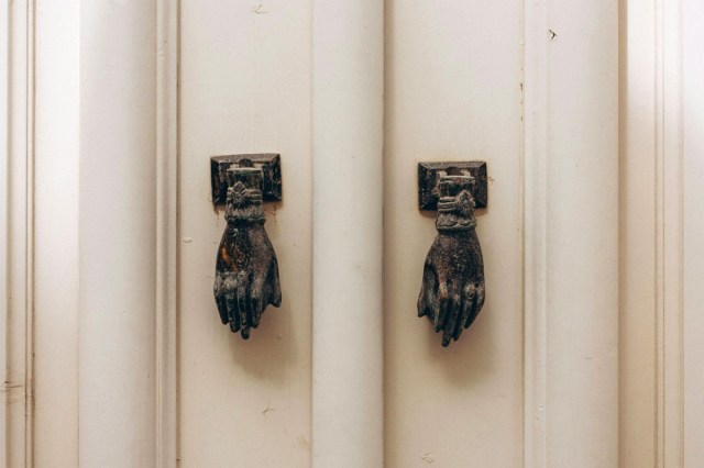 Two vintage doorknobs on two white doors