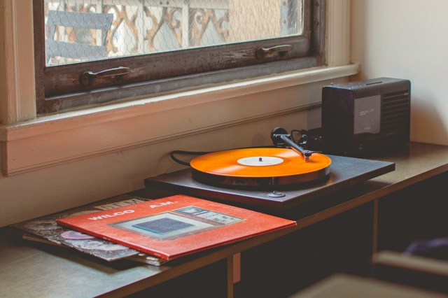 A record player with records on a shelf