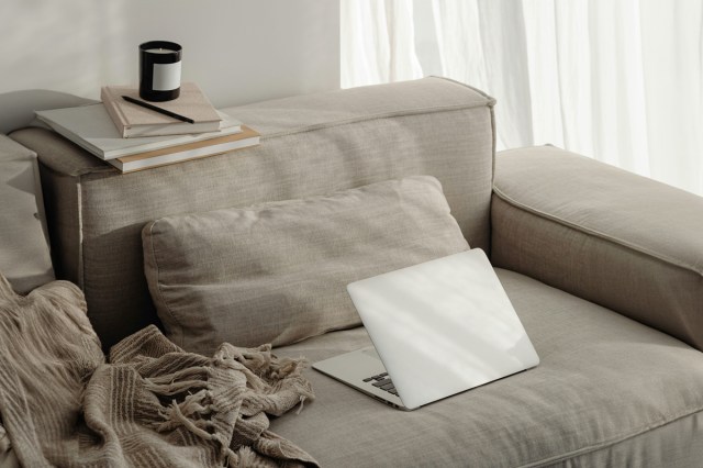 A laptop sitting open on a couch