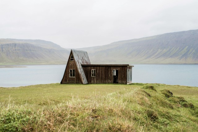 A house in a field with a lake in the background