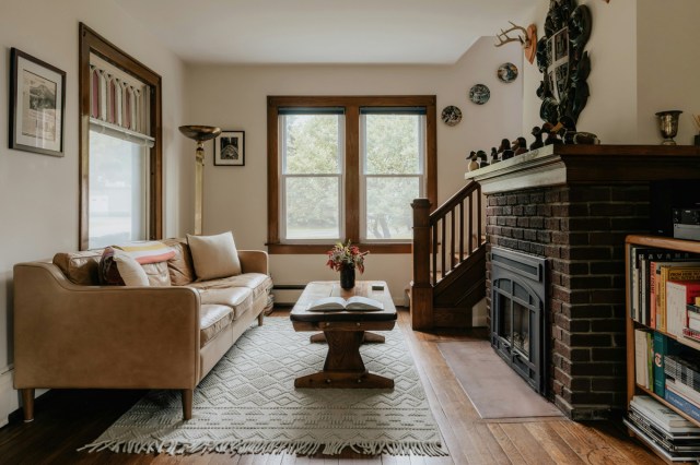 A living room with a leather couch and a fireplace 