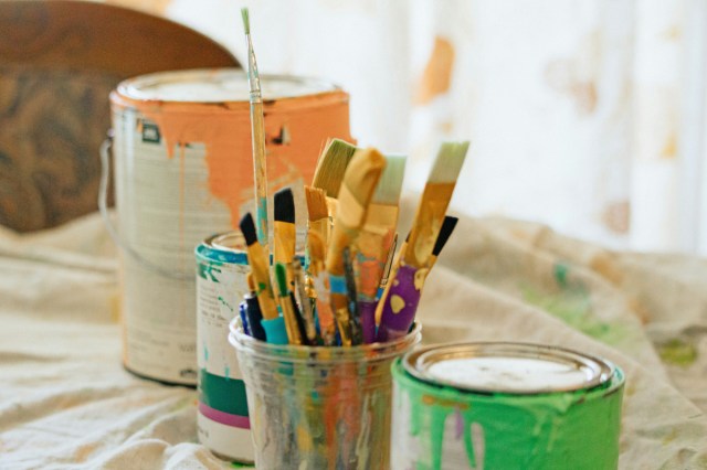 A paint can full of paint brushes