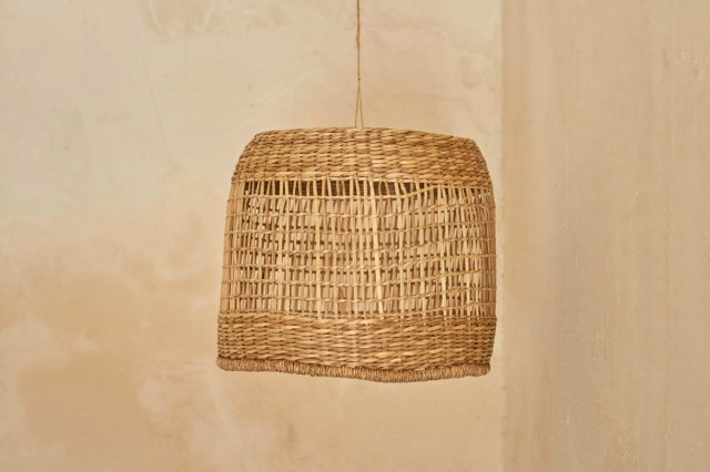 A woven lampshade hanging from a ceiling