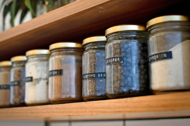 Jars on a shelf filled with different seasonings