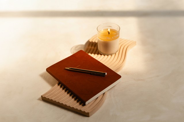 A journal with a candle and a pen 