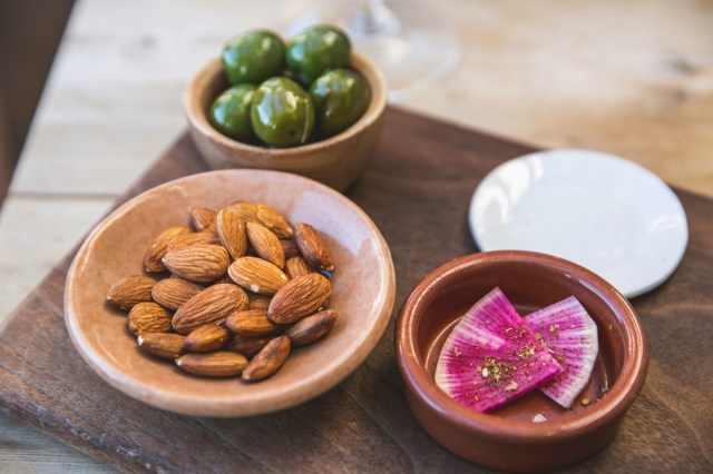 A bowl of almonds on a wooden table