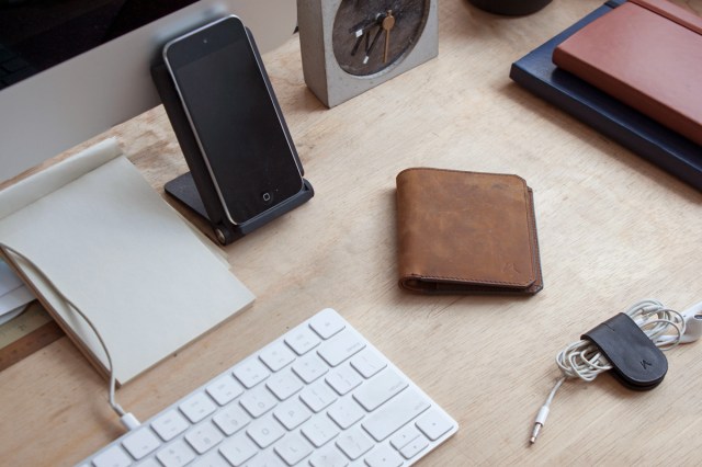 A wallet on a desk with a smart phone and computer